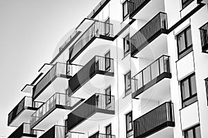 Fragment of a facade of a building with windows and balconies. Black and white.