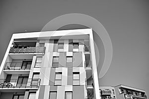 Fragment of a facade of a building with windows and balconies. Black and white.