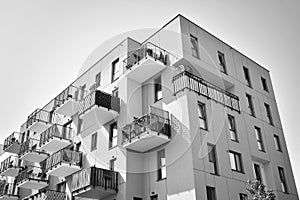 Fragment of a facade of a building with windows and balconies. Black and white.