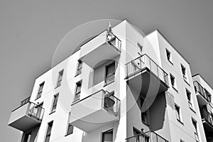 Fragment of a facade of a building with windows and balconies. Black and white.