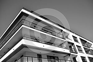 Fragment of a facade of a building with windows and balconies. Black and white.