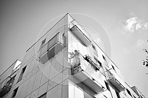 Fragment of a facade of a building with windows and balconies. Black and white.