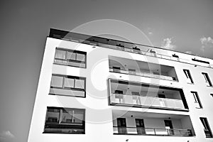 Fragment of a facade of a building with windows and balconies. Black and white.