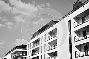 Fragment of a facade of a building with windows and balconies. Black and white.