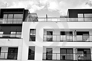 Fragment of a facade of a building with windows and balconies. Black and white.