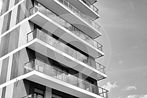 Fragment of a facade of a building with windows and balconies. Black and white.