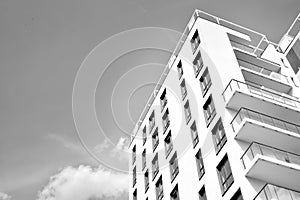 Fragment of a facade of a building with windows and balconies. Black and white.