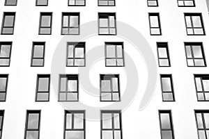 Fragment of a facade of a building with windows and balconies. Black and white.