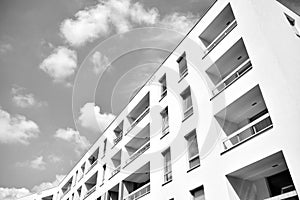 Fragment of a facade of a building with windows and balconies. Black and white.