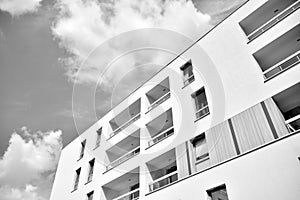 Fragment of a facade of a building with windows and balconies. Black and white.