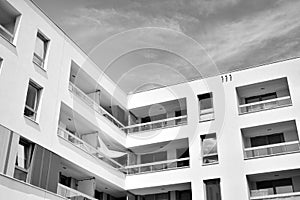 Fragment of a facade of a building with windows and balconies. Black and white.