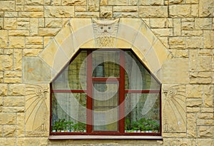 Fragment of the facade of a house with a window and an owl in the Art Nouveau style