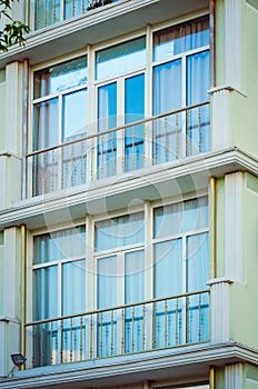Fragment of the facade of a modern apartment house with a window and a balcony