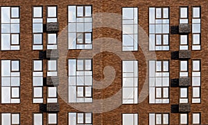 Fragment of the facade of a modern brick building. Texture materials. High windows and suspensions for air conditioner
