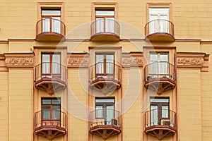 Fragment of the facade of a modern building with metal balconies and a geometric pattern