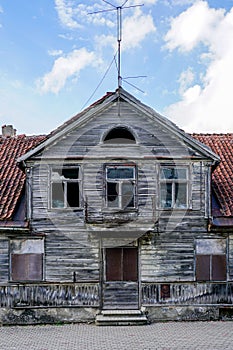 Fragment of the facade of an old wooden house with a clay roof