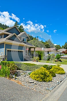 Fragment of a family house with landscaping on the front and blue sky background