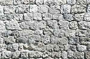 Fragment of a fortified wall made of stones and cemented with cement mortar. Black and white