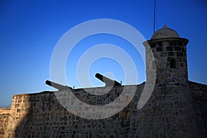 Fragment of the fortress of San Salvador de La Punta with two guns in the backlight. Malecon, Old Havana. Cuba