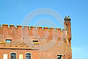 A fragment of the fortress wall of Shaaken Castle with a nest of storks on a corner tower, XIII century. Kaliningrad region