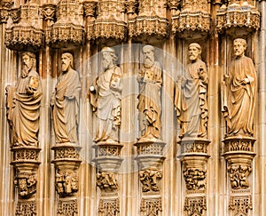 Fragment of gate with stone Apostles carving sculptural images, photo