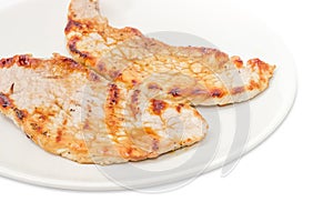 Fragment of grilled sappy pork steaks on the white dish