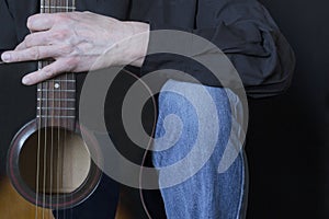 Fragment of a guitar and a guitar player close-up