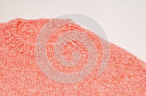 A fragment of a hand knitted woolen sweater on a white background. close up