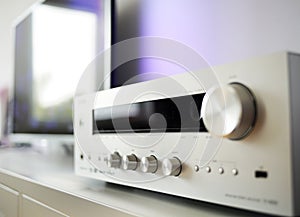 Fragment of the home stereo mini Hi-Fi music system with metal volume control knob on a foreground close-up at selective focus