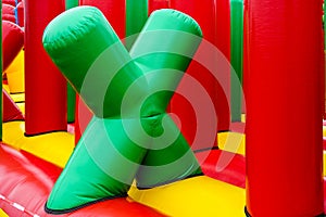 Fragment of inflatable attractions in the form of a green letter X