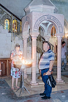 Fragment of the interior of the Church of the Holy Sepulchre in Jerusalem, Israel. Believers light candles.