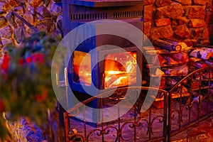 Fragment of the interior of a country house. The iron furnace is heated. There is wood near the stove. It's dark