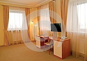 Fragment of an interior of the hotel room with a desk and a floor lamp. Modern classics