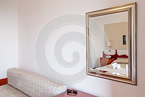 A fragment of the interior of a hotel room. The mirror reflects the decoration of the room