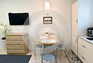 A fragment of the interior of a modern kitchen with a TV on the wall