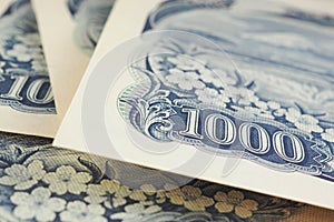 Fragment of a Japanese 1,000 yen bill close-up. Background or wallpaper about money, banks, finance and the economy of Japan.