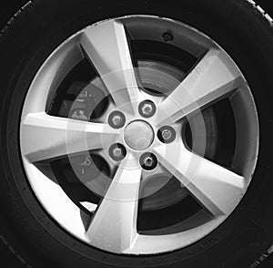 Fragment of luxury car with wheel on steel disc, closeup photo