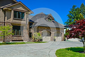 Fragment of luxury house with double garage and concrete driveway in front