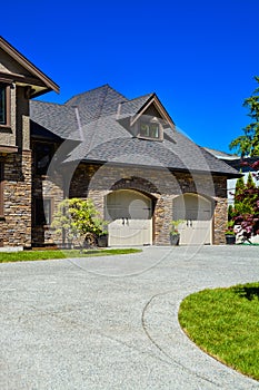 Fragment of luxury house with double garage and concrete driveway in front