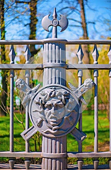Fragment of a metal fence of the Summer Garden in St. Petersburg decorated with the image of the face of the Gorgon Medusa on the