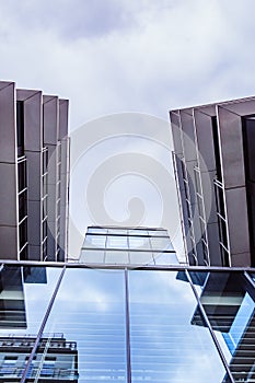 Fragment of a modern building with cloudy sky on the background