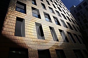 Building facade covered by copper tiles.