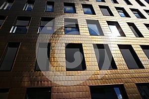 Building facade covered by copper tiles.