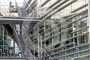 A fragment of a modern corporate building and an external stairwell. The structure is made of glass and concrete