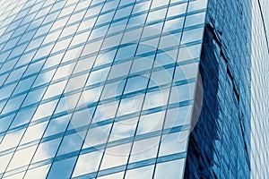 Fragment of a modern office building. Abstract geometric background. Part of a skyscraper with glass windows.