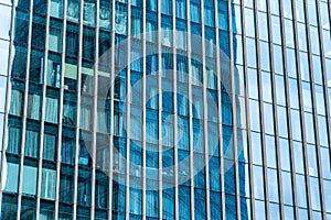 Fragment of a modern office building. Abstract geometric background. Part of a skyscraper with glass windows.