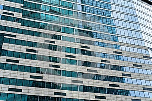 Fragment of a modern office building. Abstract geometric background. Part of a skyscraper with glass windows.