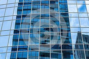 Fragment of a modern office building. Abstract geometric background. Part of a skyscraper with glass windows.