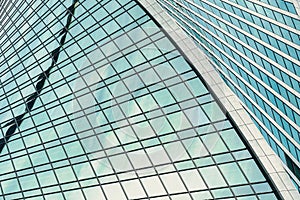 Fragment of a modern office building. Abstract geometric background. Part of a skyscraper with glass windows.