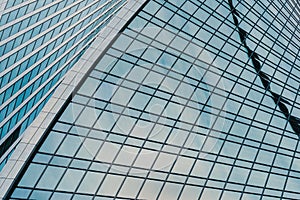 Fragment of a modern office building. Abstract geometric background. Part of a skyscraper with glass windows.